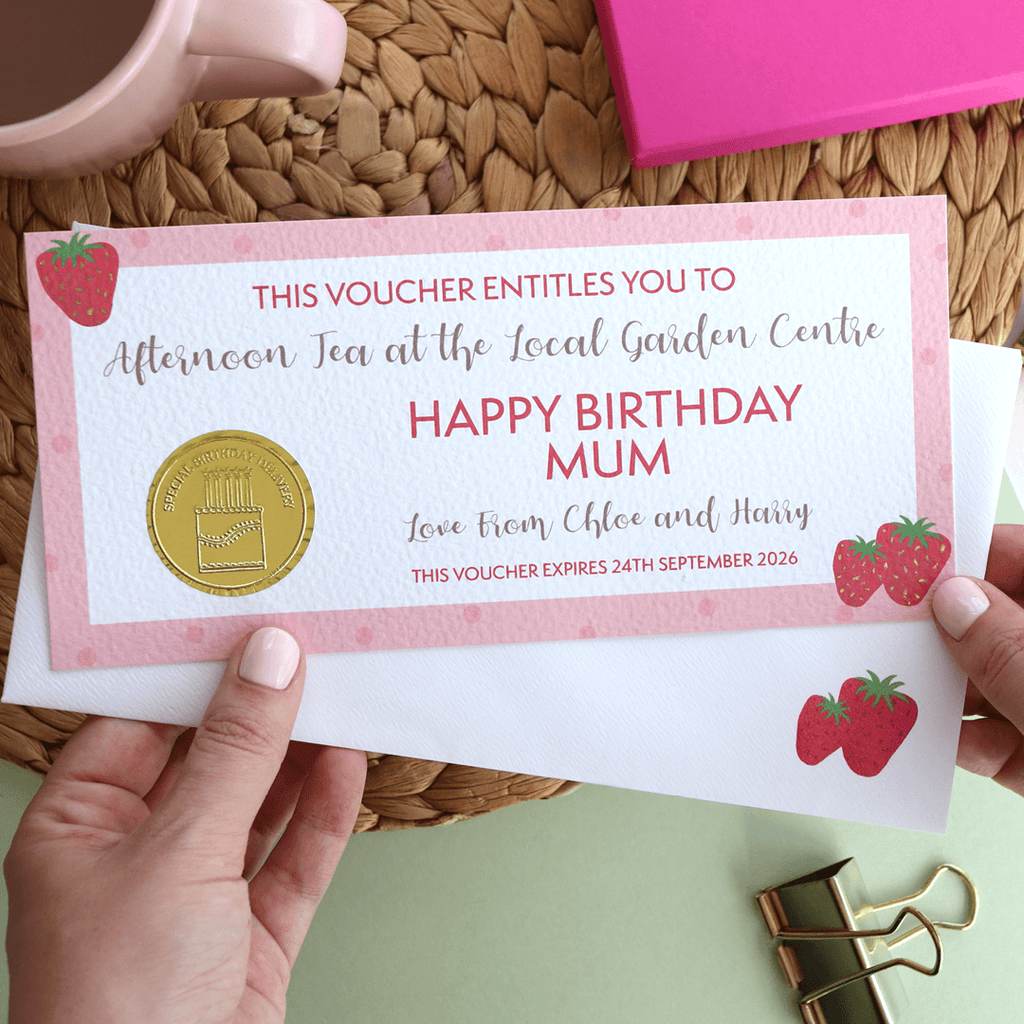 Personalised gift voucher on luxury textured card, featuring a pink design with strawberries, a gold embossed foil seal, and a kraft envelope