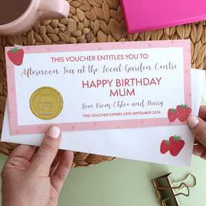 Personalised gift voucher on luxury textured card, featuring a pink design with strawberries, a gold embossed foil seal, and a kraft envelope
